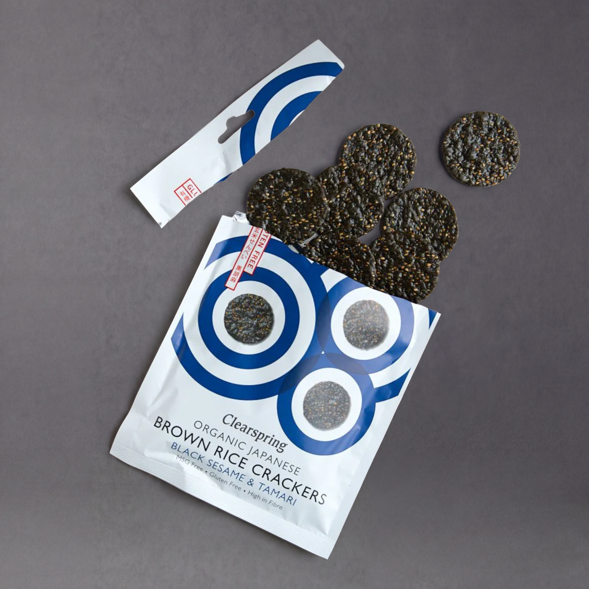 Clear images of Clearspring Rice Crackers by GRAINED featuring black sesame seeds and tamari seasoning on crispy brown rice crackers.