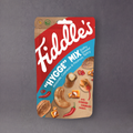 Assorted Fiddle's Snacks trail mix with nuts, dried fruits, and chocolate pieces in a clear bowl.