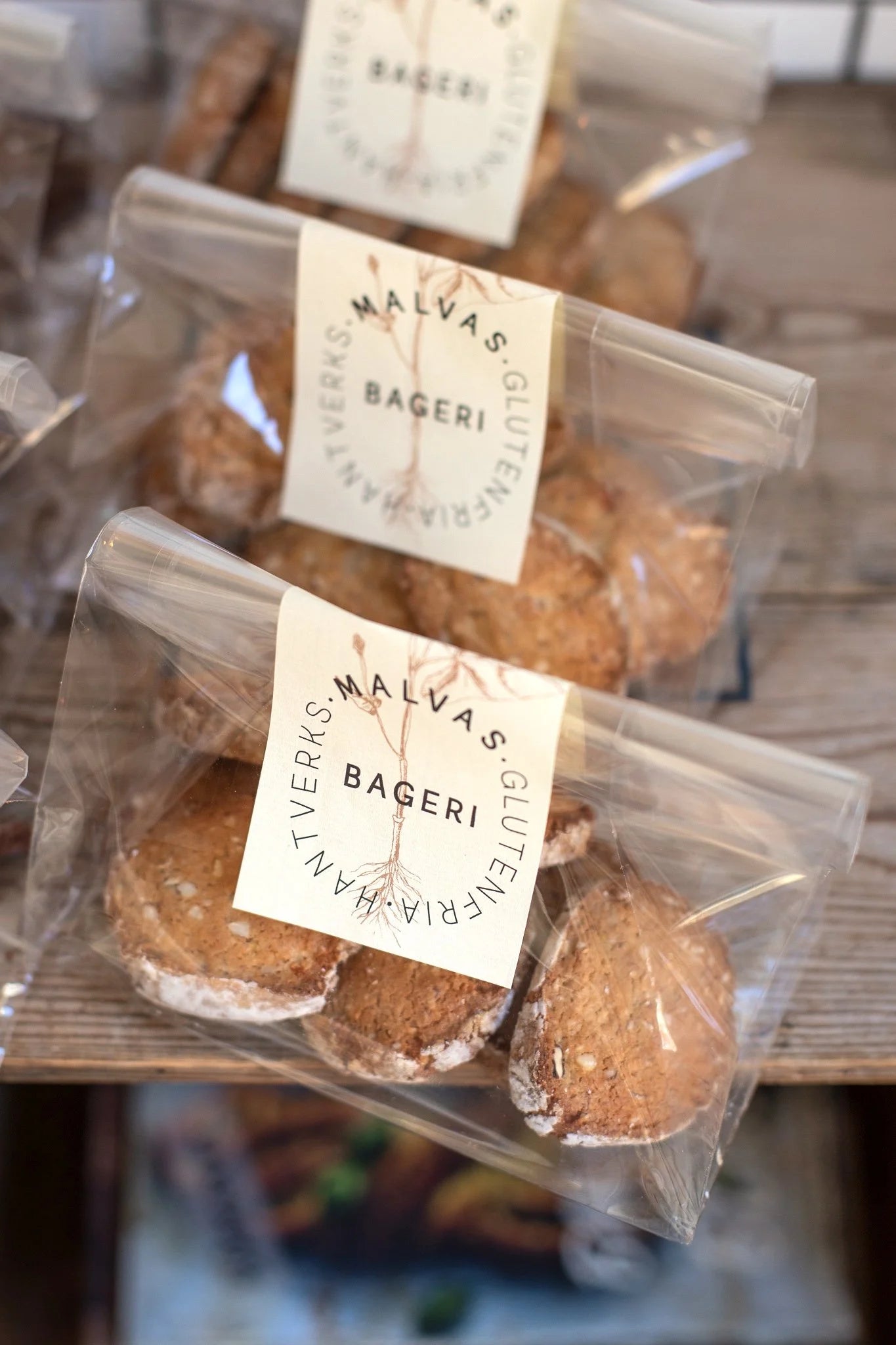GRAINED Malva's Cookies gourmet Swedish handmade cookies in four flavors, displayed on a rustic wooden surface.