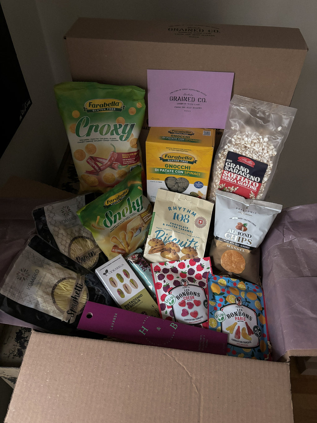 Assorted packaged food items in a box with visible brand names.