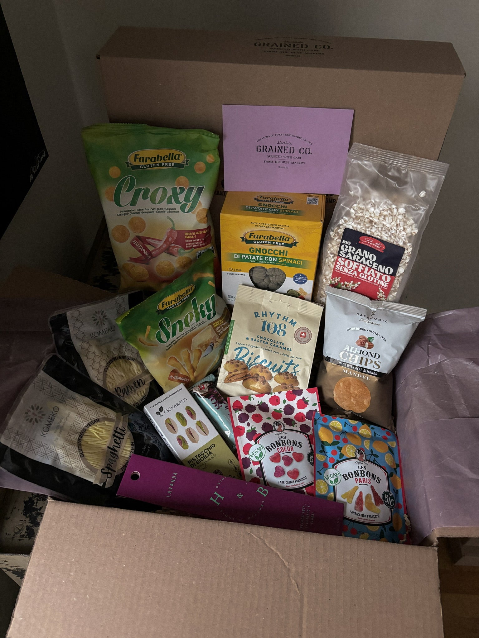 Assorted packaged food items in a box with visible brand names.