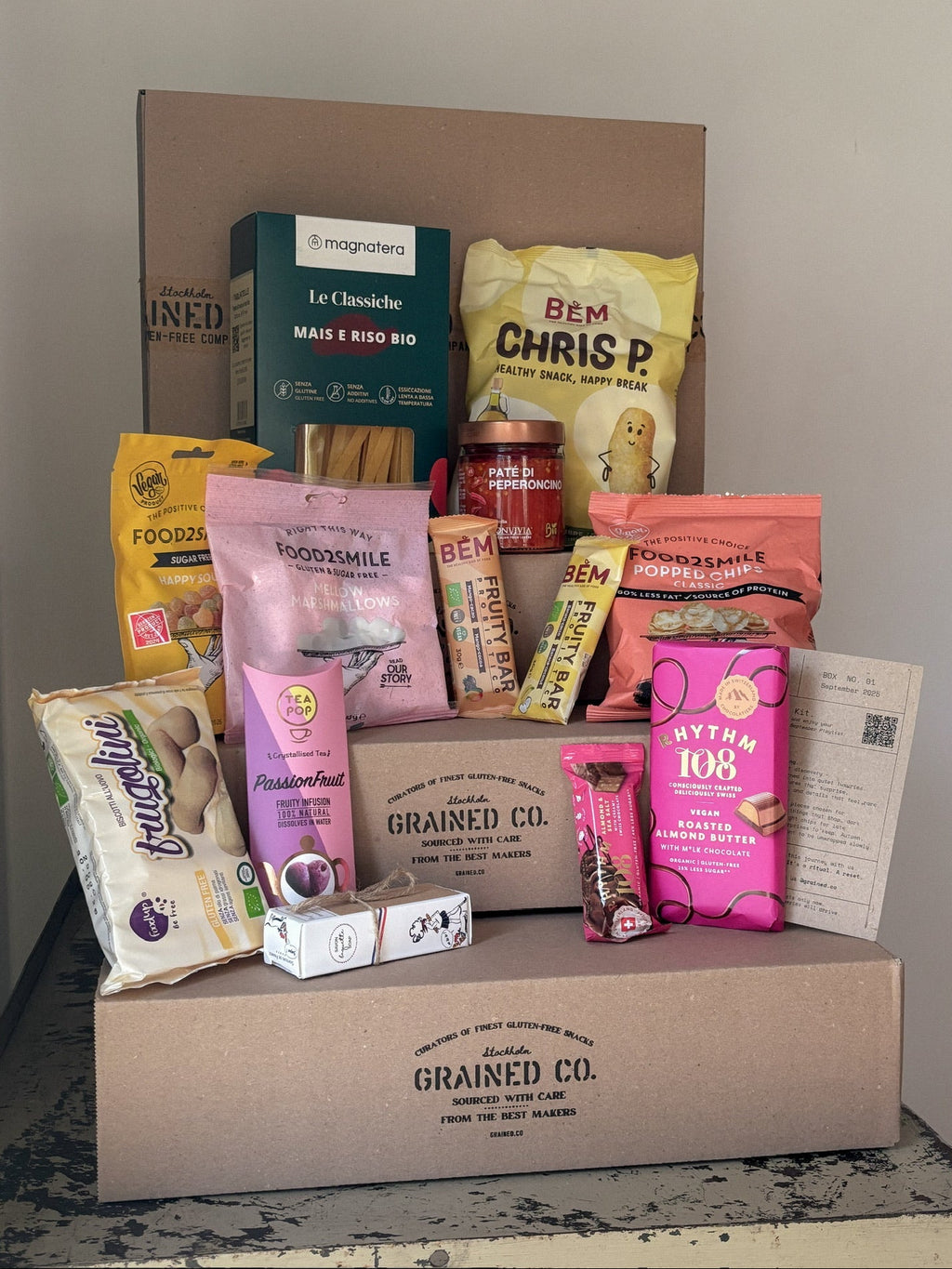 Collection of gluten-free food products and snacks from Grained Co. gluten-free company on a wooden surface.