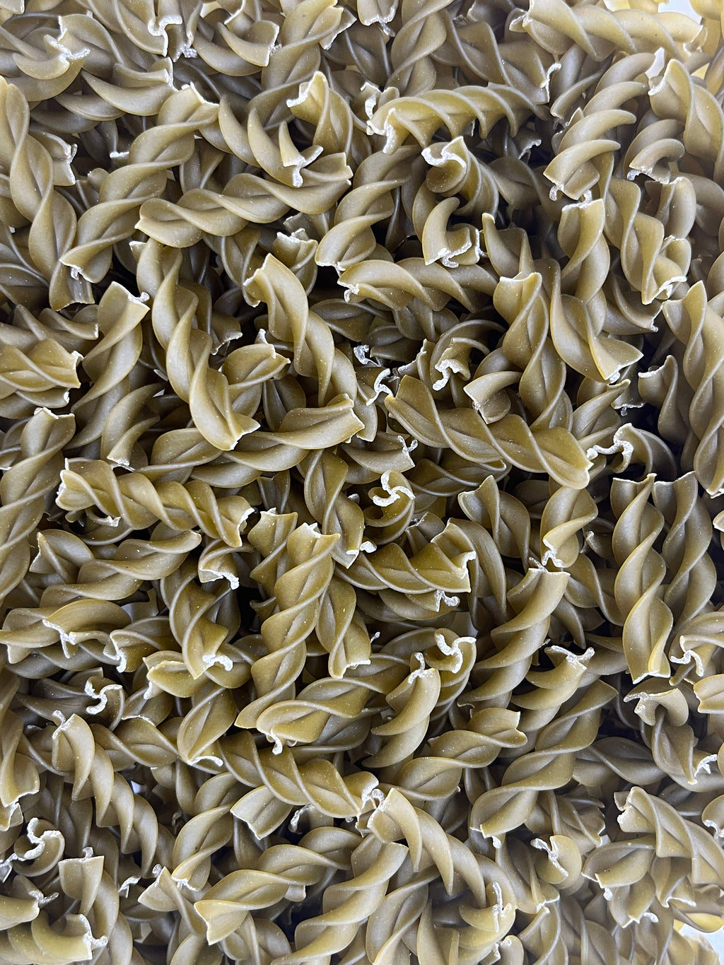 Gustosa Green Pea Fusilli pasta made from 100% organic green peas, gluten-free, with a close-up of the green pea pasta shape.